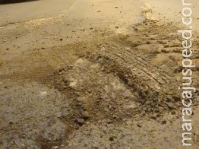 Moradores estranham buracos no asfalto sendo tapados só com areia