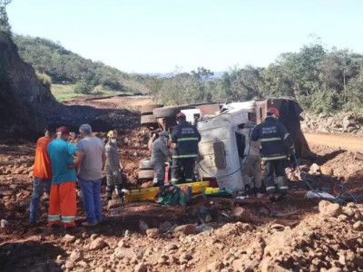Caminhão com pedras tomba e motorista fica preso nas ferragens