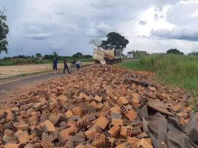 Carroceria de carreta abre e carga de tijolos fica espalhada em rodovia