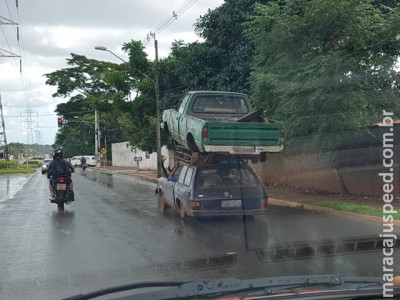 Condutor de carro transporta caminhonete no capô