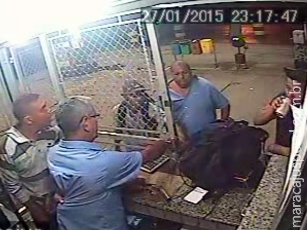 Homem bebe cerveja tranquilamente durante assalto a posto Homem bebe cerveja tranquilamente durante assalto a posto