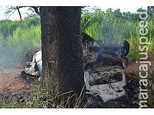 Carro tomba após bater em árvore, pega fogo, mas ocupantes se salvam Carro tomba após bater em árvore, pega fogo, mas ocupantes se salvam