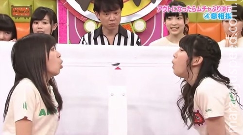 Jovens tentam soprar barata na boca de outras em jogo japonês