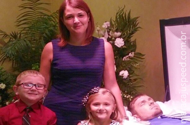 Sorridente viúva posa com os filhos ao lado do marido morto