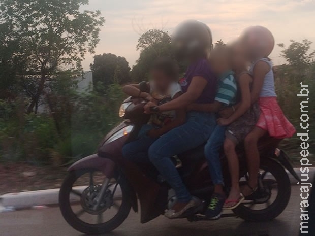 Mulher é flagrada transportando 4 crianças em motocicleta Mulher é flagrada transportando 4 crianças em motocicleta