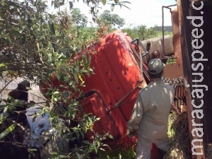 Motorista perde controle de carreta, cai em ribanceira e fica preso às ferragens