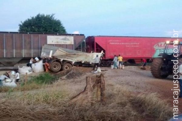 Caminhão bitrem para em trilhos e é atingido por trem de carga 