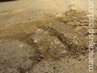 Moradores estranham buracos no asfalto sendo tapados só com areia