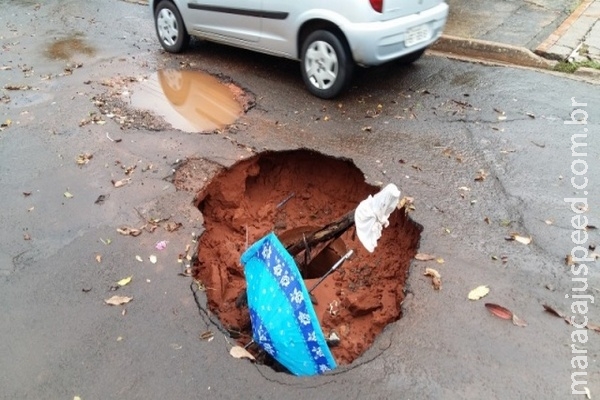 Sem manutenção, buraco em rua cresce e chega à rede de drenagem Sem manutenção, buraco em rua cresce e chega à rede de drenagem