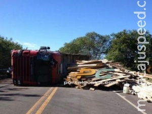 Carreta carregada com estacas de madeira tomba sobre ponte na BR-163