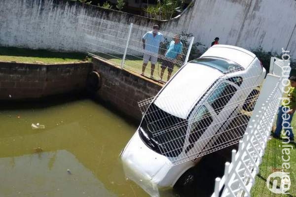 Motorista estaciona, esquece de puxar freio de mão e veículo cai em buraco Motorista estaciona, esquece de puxar freio de mão e veículo cai em buraco