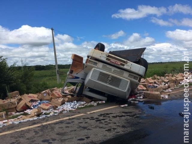 Motorista morre após caminhão carregado com cigarros capotar