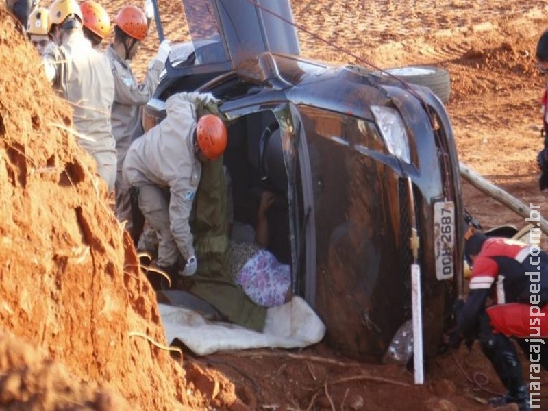 Motorista se distrai ao pegar objeto no carro, capota e invade canteiro de obra