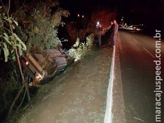 Carro capota e fica preso em árvores às margens de córrego na Ernesto Geisel Carro capota e fica preso em árvores às margens de córrego na Ernesto Geisel