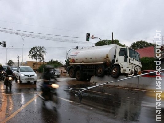 Motorista tenta evitar colisão e caminhão vai parar em cima de mureta Motorista tenta evitar colisão e caminhão vai parar em cima de mureta