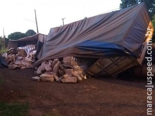 Carreta com carga de açúcar tomba em valeta formada pela enxurrada Carreta com carga de açúcar tomba em valeta formada pela enxurrada