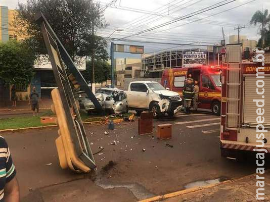 Colisão termina com mulher presa nas ferragens e semáforo no chão