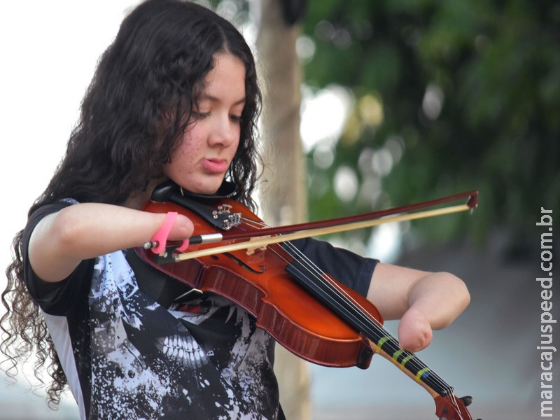 Adolescente supera malformação nos braços e aprende a tocar violino adaptado por professora: 