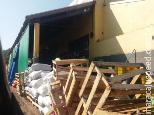 Mercado usa calçada para expor bancas e fecha com grades durante a noite