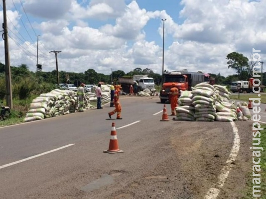 Carreta carregada com sacos de sementes tomba em rotatória