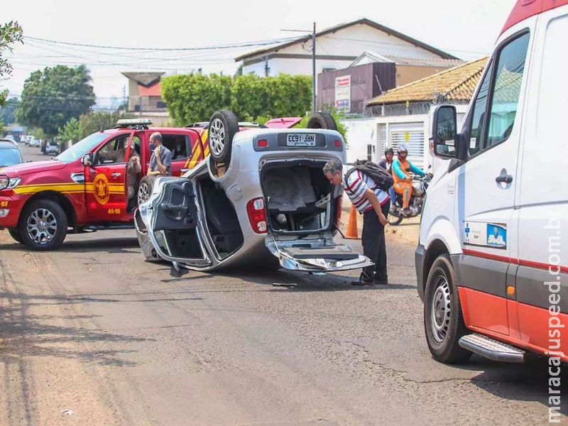 Padre desvia de ciclista, bate em carro parado e capota Fiat Uno 
