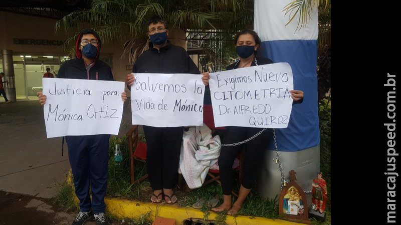 Para conseguir exame para a filha com câncer, mãe se acorrenta em frente a hospital no Paraguai Para conseguir exame para a filha com câncer, mãe se acorrenta em frente a hospital no Paraguai