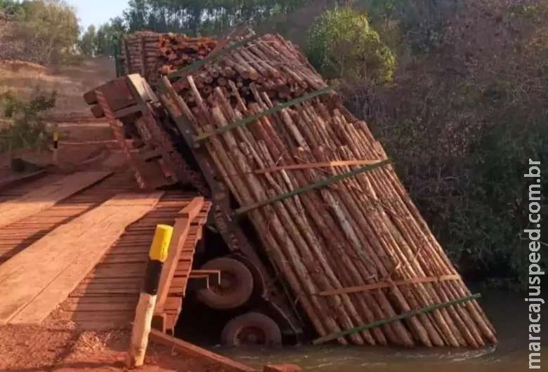 Carregada com eucalipto, carreta tenta atravessar ponte e cai em rio Carregada com eucalipto, carreta tenta atravessar ponte e cai em rio