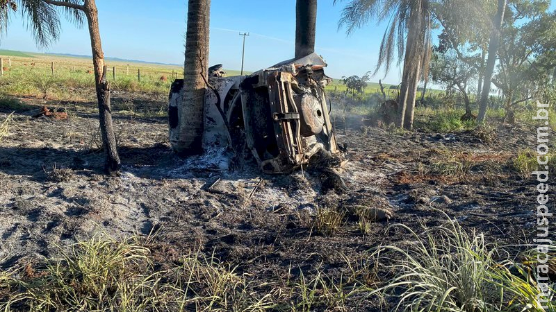 Dois corpos carbonizados são retirados de carro que bateu em coqueiro em rodovia em MS Dois corpos carbonizados são retirados de carro que bateu em coqueiro em rodovia em MS
