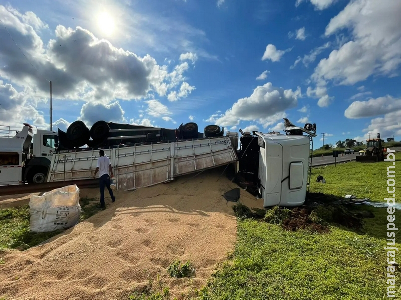 Caminhão com soja tomba ao ser atingido por caminhonete e carga fica espalhada pela BR-163