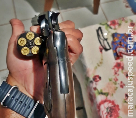 Homem se deita na cama de casal e manda foto ao lado de revolver para a esposa