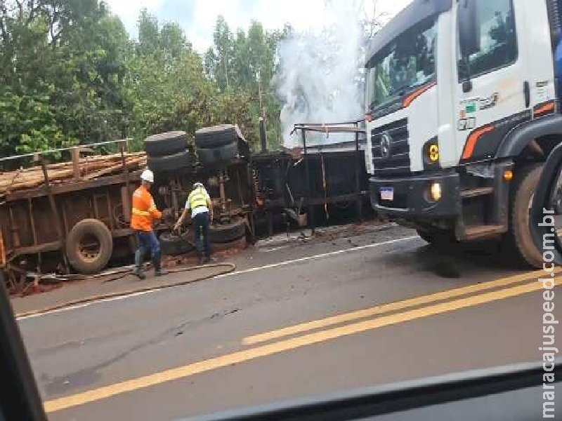 Carreta com eucalipto tomba e é consumida pelo fogo na BR-262 